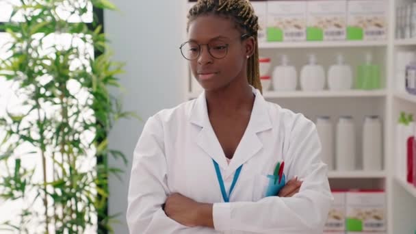 アフリカ系アメリカ人女性薬剤師笑顔自信を持って立ってとともに腕交差ジェスチャーで薬局 — ストック動画