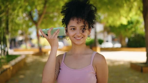 Young Hispanic Woman Smiling Confident Listening Audio Message Smartphone Park – Stock-video