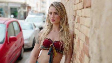 Sokakta kendine güvenen genç sarışın kadın gülümsüyor