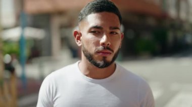 Young latin man smiling confident standing at street