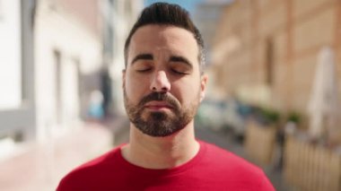 Sokakta kendinden emin gülümseyen İspanyol genç adam.