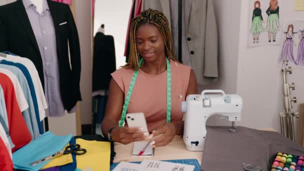 非洲裔美国妇女裁缝笑着自信地在裁缝店用智能手机自拍 — 图库视频影像