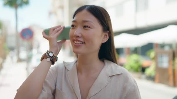 Chińska Kobieta Uśmiecha Się Pewnie Słuchając Wiadomości Audio Przez Smartfona — Wideo stockowe