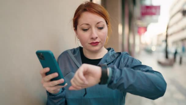 Young Redhead Woman Wearing Sportswear Using Smartphone Smartwatch Street — Wideo stockowe