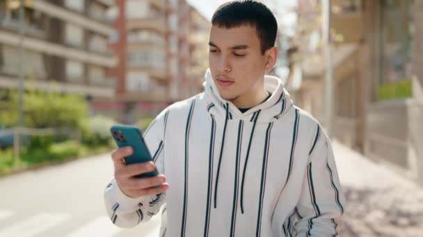 年轻人笑着自信地在街上用智能手机自立门户 — 图库视频影像