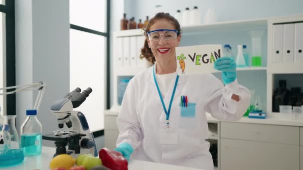 Donna Mezza Età Indossa Uniforme Scienziato Tenendo Banner Vegan Laboratorio — Video Stock