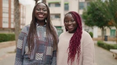 Two african american women smiling confident making selfie by the smartphone at park