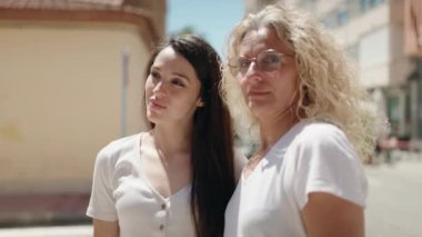 İki kadın anne ve kızı sokakta birbirlerine sarılıyorlar.