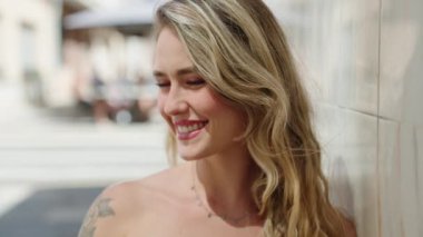 Sokakta kendine güvenen genç sarışın kadın gülümsüyor