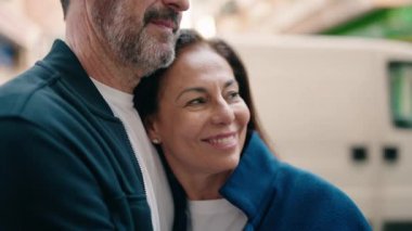 Man and woman couple hugging each other standing at street