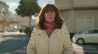 Middle age redhead woman smiling confident standing at street
