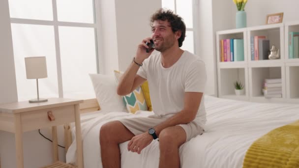 Jonge Spaanse Man Aan Het Praten Smartphone Zittend Bed Slaapkamer — Stockvideo