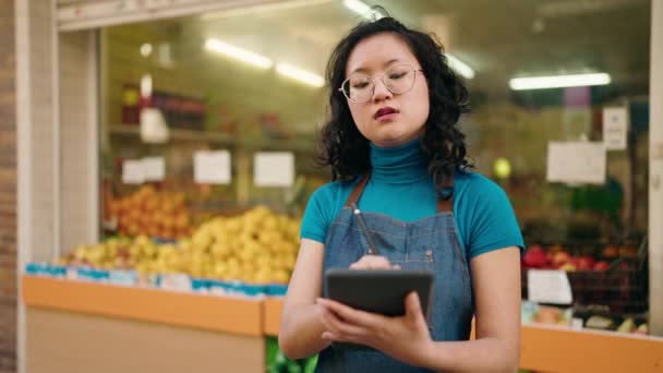 Young Chinese Woman Employee Smiling Confident Using Touchpad Fruit Store — Stock video