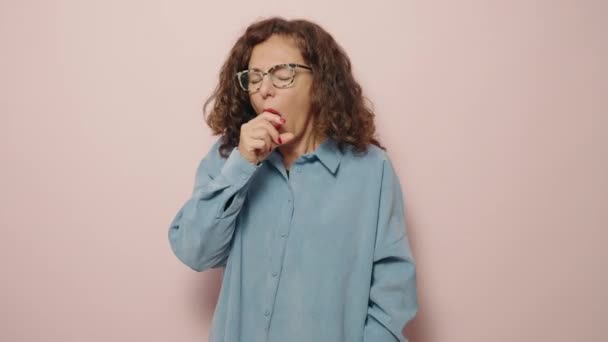 中年女性咳以上ピンクの背景 — ストック動画