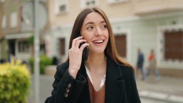 年轻的惊慌失措的女人在街上用智能手机自信地微笑着 — 图库视频影像