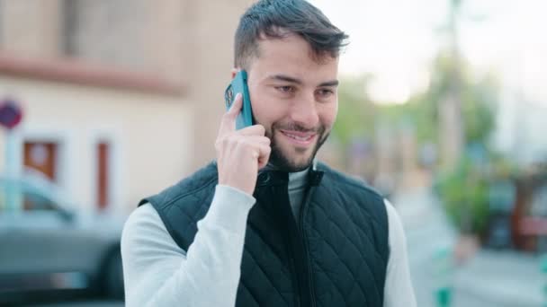 Genç Spanyol Adam Gülümsüyor Kendine Güveniyor Sokakta Akıllı Telefondan Konuşuyor — Stok video