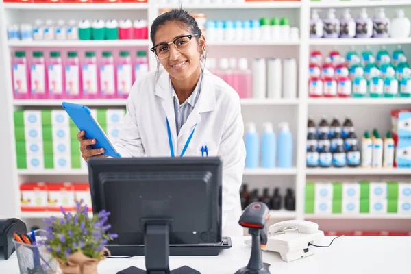 年轻美丽的惊慌失措的女药剂师用触摸板和在药店工作的电脑 — 图库照片