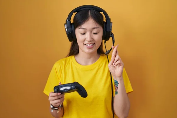 Mujer Joven China Jugando Videojuego Sosteniendo Controlador Gesto Cruzado Sonriendo —  Fotos de Stock