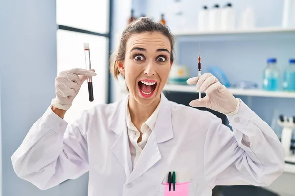 Νεαρή Γυναίκα Που Εργάζονται Εργαστήριο Επιστήμονας Κρατώντας Δείγμα Αίματος Γιορτάζει — Φωτογραφία Αρχείου