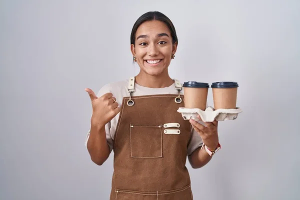Mujer Hispana Joven Con Delantal Camarera Profesional Sosteniendo Café Apuntando —  Fotos de Stock