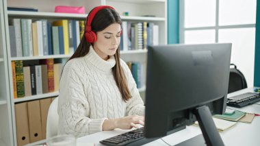 Üniversite sınıfında bilgisayar kullanan güzel İspanyol bir kız öğrenci.