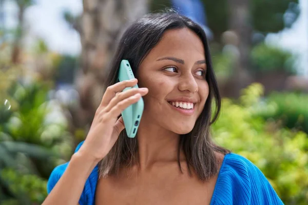 若いヒスパニック系の女性は 公園でスマートフォンで自信を持って話して笑顔 — ストック写真