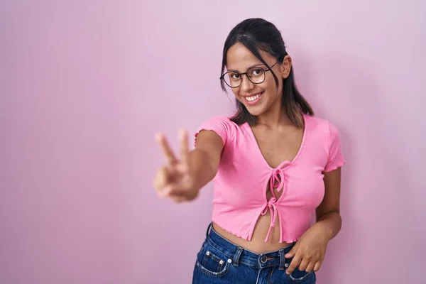 Латиноамериканская Молодая Женщина Стоящая Розовом Фоне Очках Улыбаясь Смотрит Камеру — стоковое фото