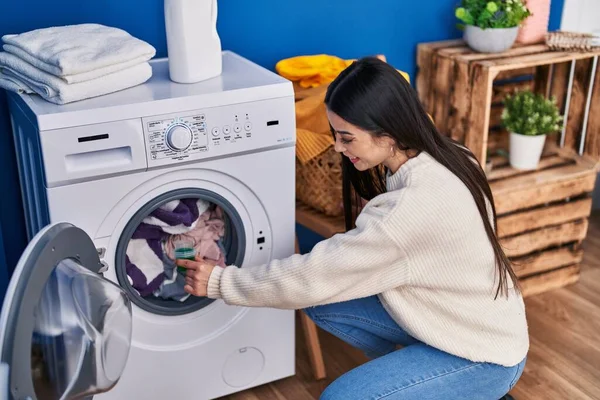 年轻美丽的惊慌失措的女人微笑着 自信地把洗涤剂倒在洗衣房的洗衣机上 — 图库照片