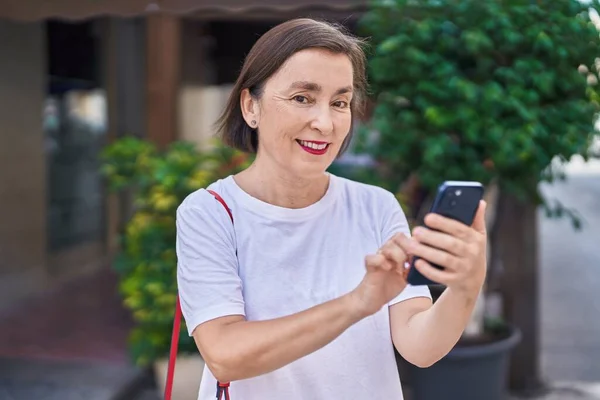 Жінка Середнього Віку Посміхається Впевнено Використовуючи Смартфон Вулиці — стокове фото