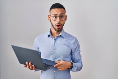 Şok suratlı, bilgisayar bilgisayarı kullanan genç İspanyol adam şüpheci ve alaycı görünüyor, ağzı açık kalınca şaşırıyor. 