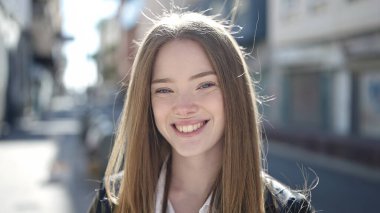 Sokakta kendine güvenen genç sarışın kadın gülümsüyor