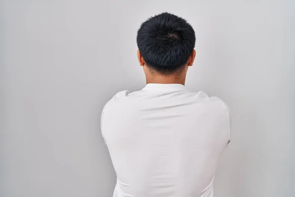 Νεαρός Κινέζος Στέκεται Πάνω Από Λευκό Φόντο Στέκεται Πίσω Κοιτάζοντας — Φωτογραφία Αρχείου