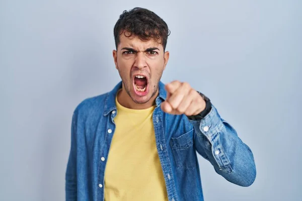 Mladý Hispánec Který Stojí Nad Modrým Pozadím Ukazuje Kameru Rozzlobený — Stock fotografie