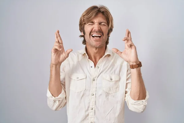 Middle Age Man Standing Isolated Background Gesturing Finger Crossed Smiling — Stock Photo, Image