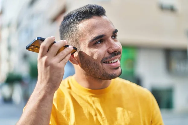 Молодой Латиноамериканец Улыбается Уверенно Слушая Аудиосообщение Смартфона Улице — стоковое фото