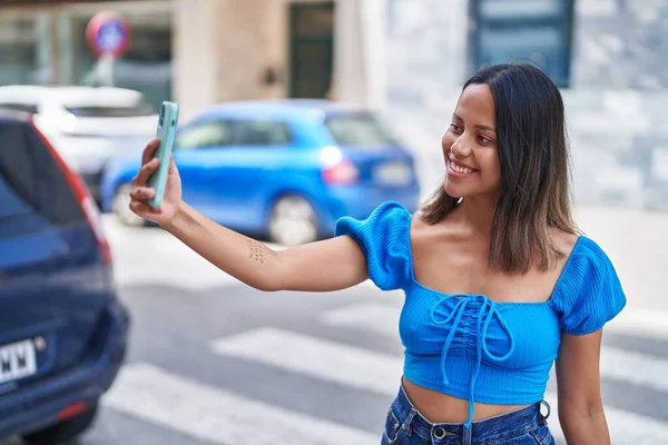 若いですヒスパニック女性笑顔作る自信のある自画撮りによってザスマートフォンでストリート — ストック写真