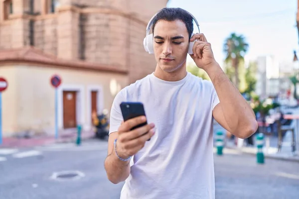 Young Hispanic Man Listening Music Standing Street — Φωτογραφία Αρχείου
