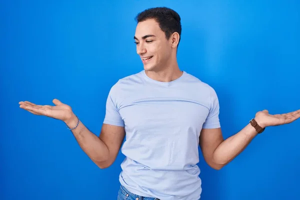 Young Hispanic Man Standing Blue Background Smiling Showing Both Hands — Foto de Stock
