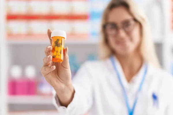 Young Blonde Woman Pharmacist Smiling Confident Holding Pills Bottle Pharmacy — ストック写真