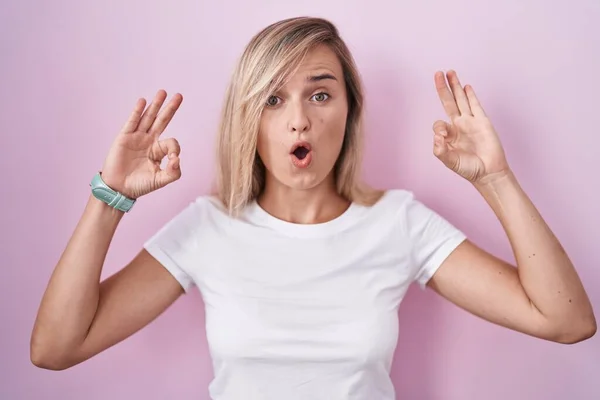 Young Blonde Woman Standing Pink Background Looking Surprised Shocked Doing — Stock fotografie