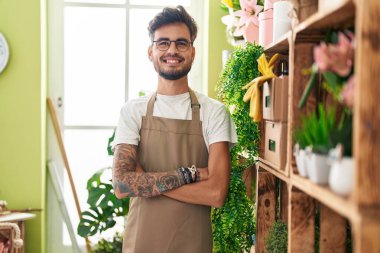 Çiçekçide kollarını kavuşturup duran kendine güvenen genç İspanyol çiçekçi.