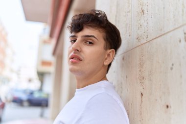 İkili olmayan adam sokakta ciddi bir ifadeyle ayakta duruyor