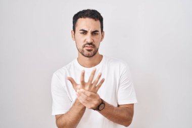 Beyaz arka planda duran yakışıklı İspanyol adam ellerinde ve parmaklarında ağrı, eklem iltihabı. 