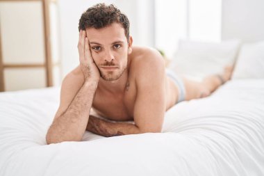 Genç İspanyol adam yatak odasında rahat bir ifadeyle yatakta yatıyor.