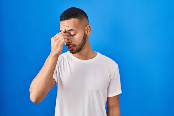 Young Hispanic Man Standing Blue Background Tired Rubbing Nose Eyes — Stock fotografie