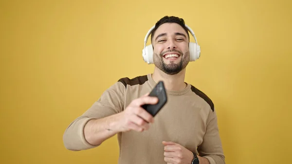Νεαρός Άραβας Χαμογελάει Αυτοπεποίθηση Ακούγοντας Μουσική Και Χορεύοντας Απομονωμένο Κίτρινο — Φωτογραφία Αρχείου