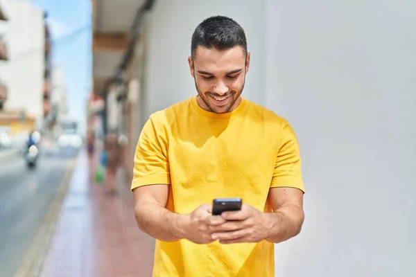 Jonge Spaanse Man Glimlacht Vol Vertrouwen Met Behulp Van Smartphone — Stockfoto