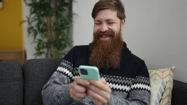 Young Redhead Man Using Smartphone Sitting Sofa Home — Fotografia de Stock