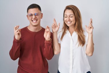 Anne ve oğlu izole edilmiş arka planda yan yana duruyorlar. Umut ve gözler kapalı gülümseyerek el sallıyorlar. Şans ve batıl inançlar. 