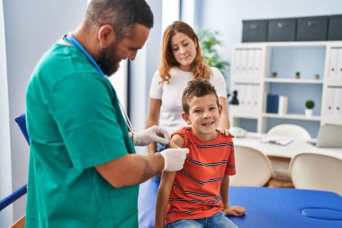 Aile aşısı yapan çocuk klinikte tıbbi danışmanlık alıyor.